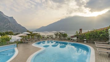 Una piscina al aire libre, sillones reclinables de piscina