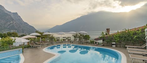 Una piscina al aire libre, sillones reclinables de piscina