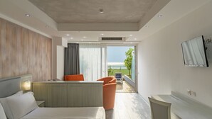 A modern hotel room with a bed, a desk, and a view of the outdoors. - Garda Suite Hotel  (Limone sul Garda)