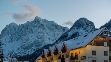 Un hotel con varios balcones, un paisaje montañoso de fondo y el nombre 'VITRANC' en el edificio.