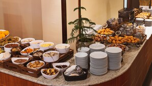 Un buffet proposant une variété de plats et d’ustensiles de service.