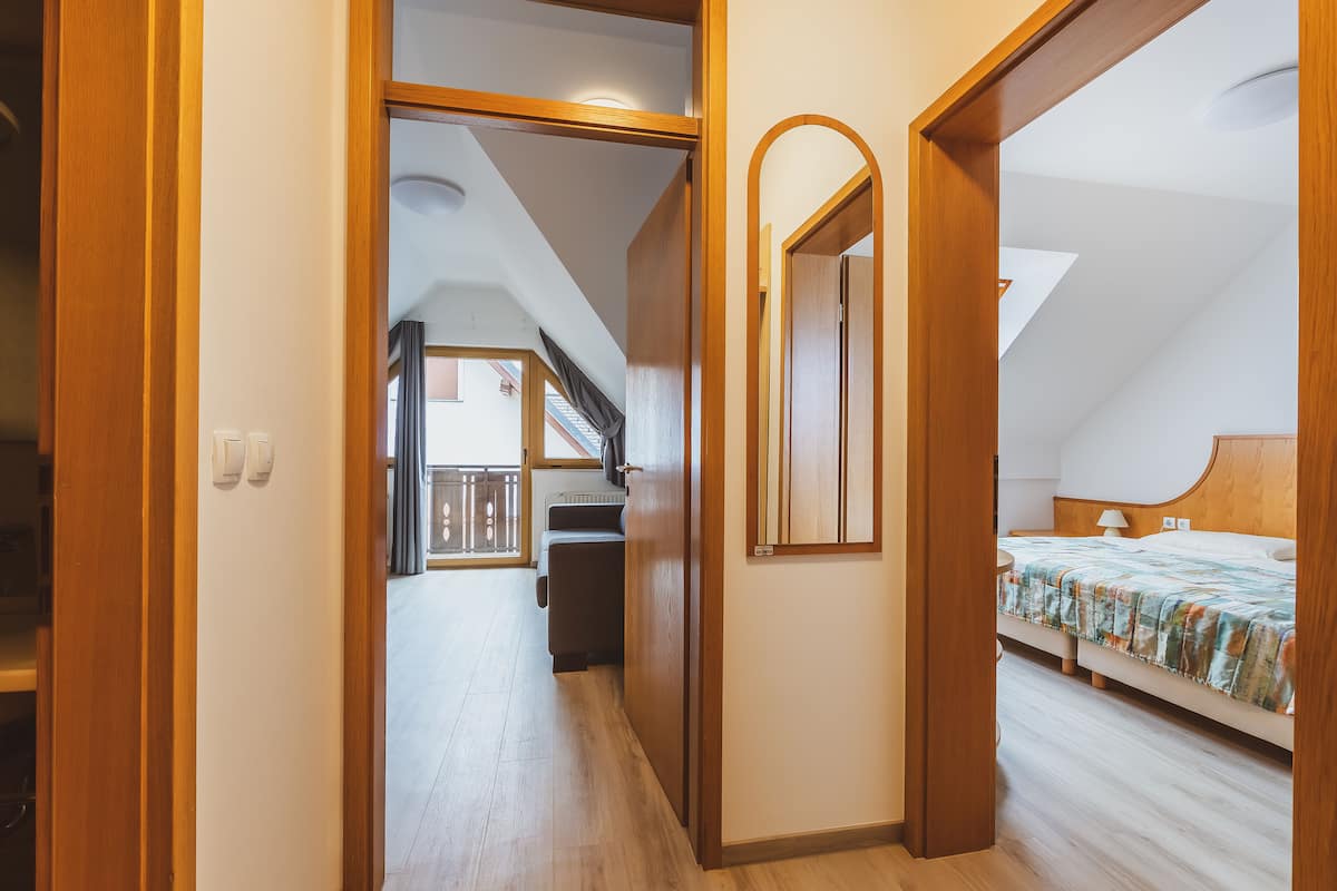 Ein Schlafzimmer mit einem Bett, einem Nachttisch und einem Spiegel. Eine Treppe führt zu einer oberen Ebene.