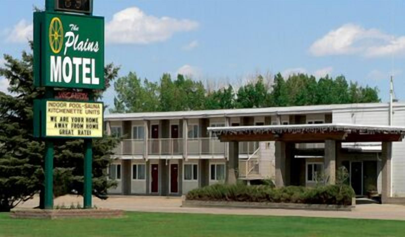 A motel with a signboard advertising indoor pool, sauna, and kitchenette units.