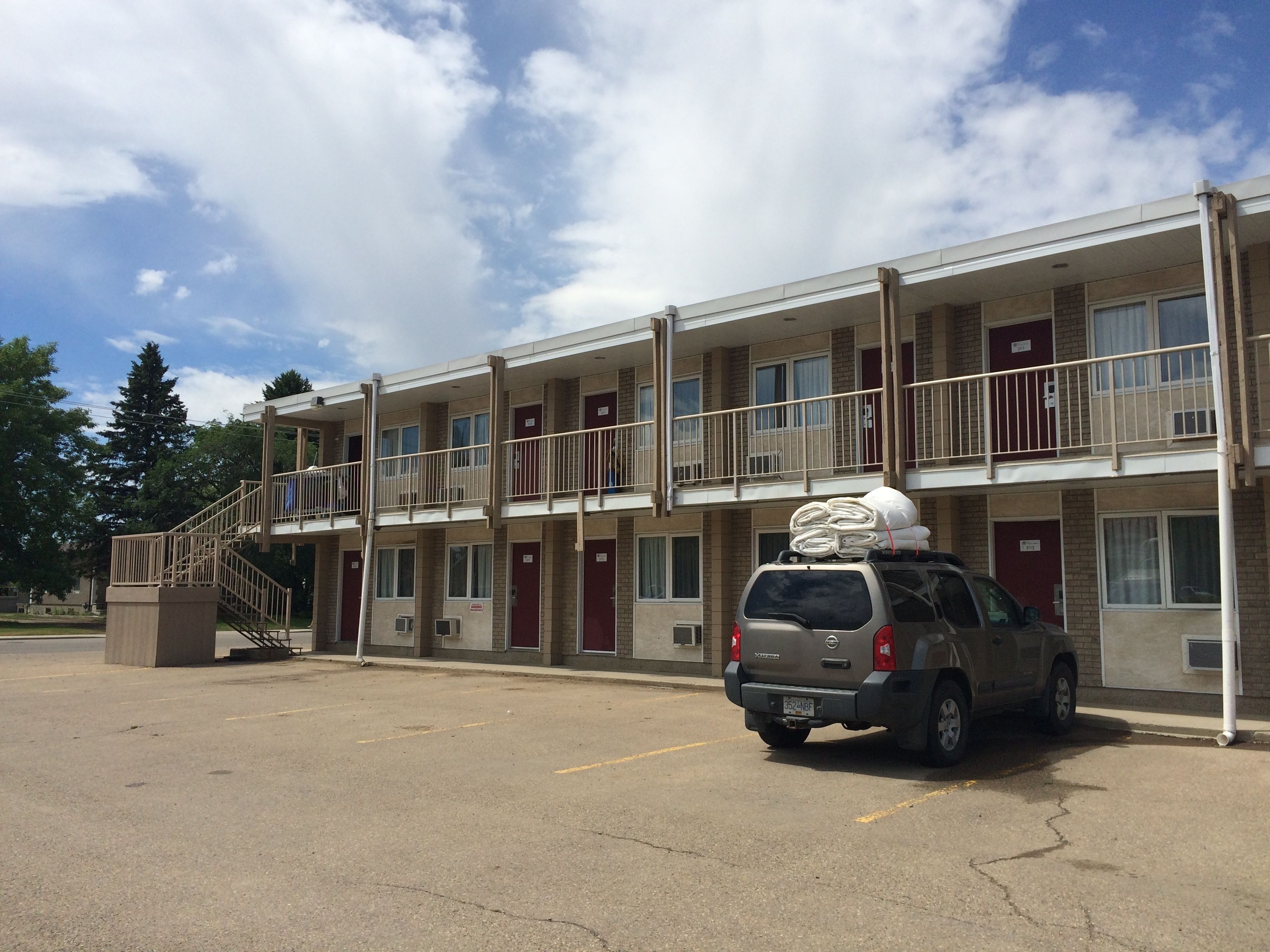 A multi-story motel with a parking lot.