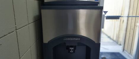 Dispensador de hielo Scotman con panel de control Prodigy Plus, situado junto a un muro de ladrillo.