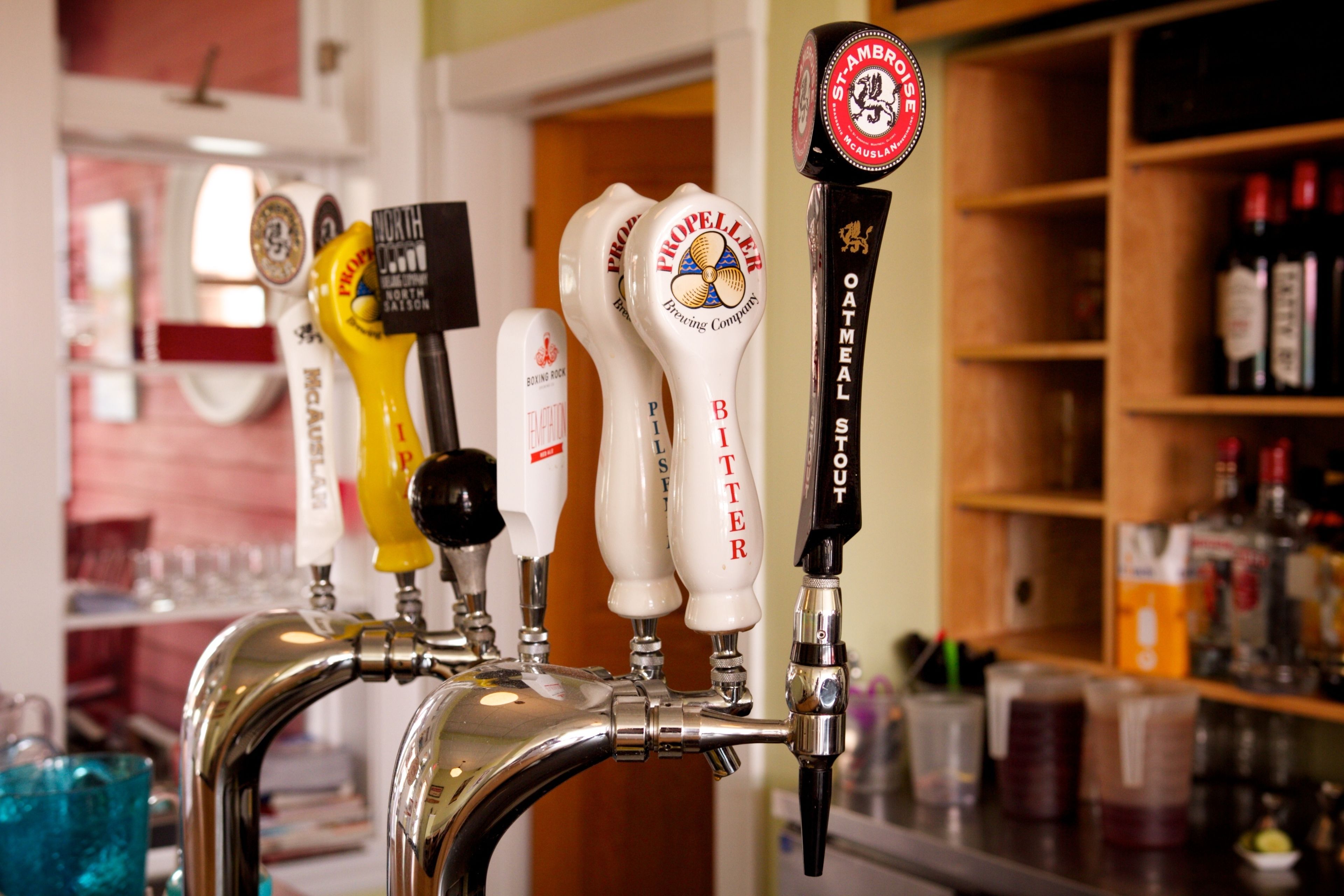 Un grifo con varios caños de cerveza, incluyendo marcas como North Point y Bitter, en un bar.