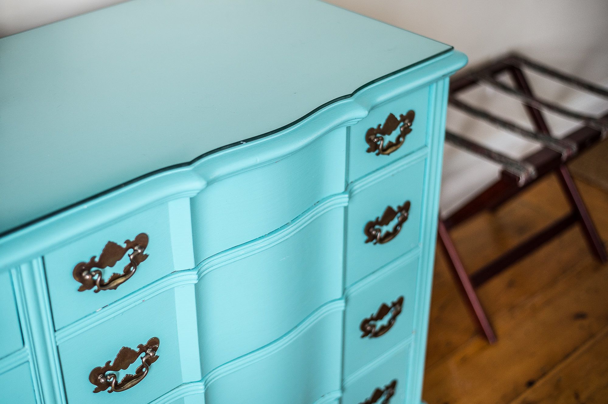Une commode bleu clair, dotée de poignées décoratives et de nombreux tiroirs.