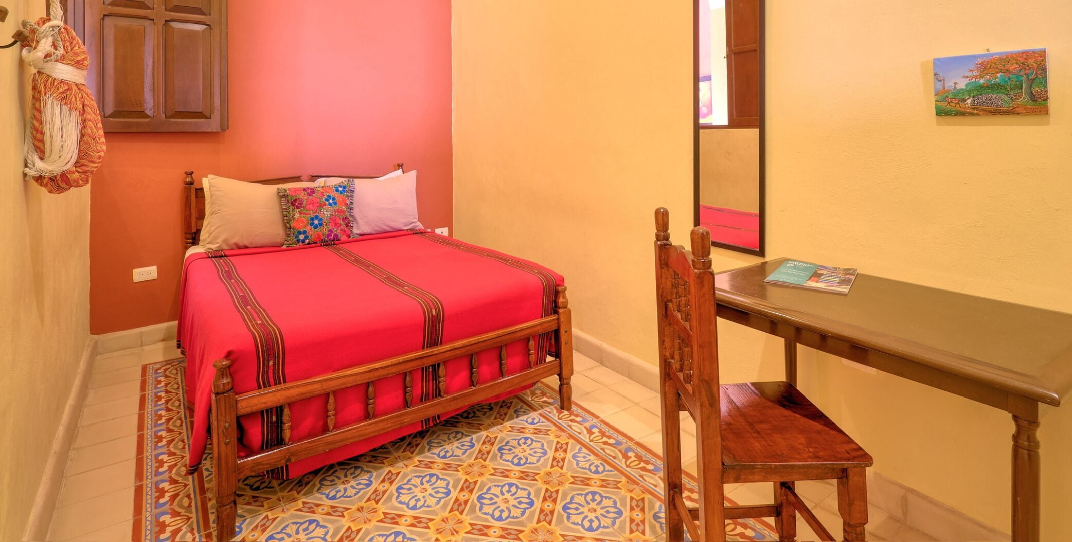 Un dormitorio con una cama de madera, un escritorio y una silla.