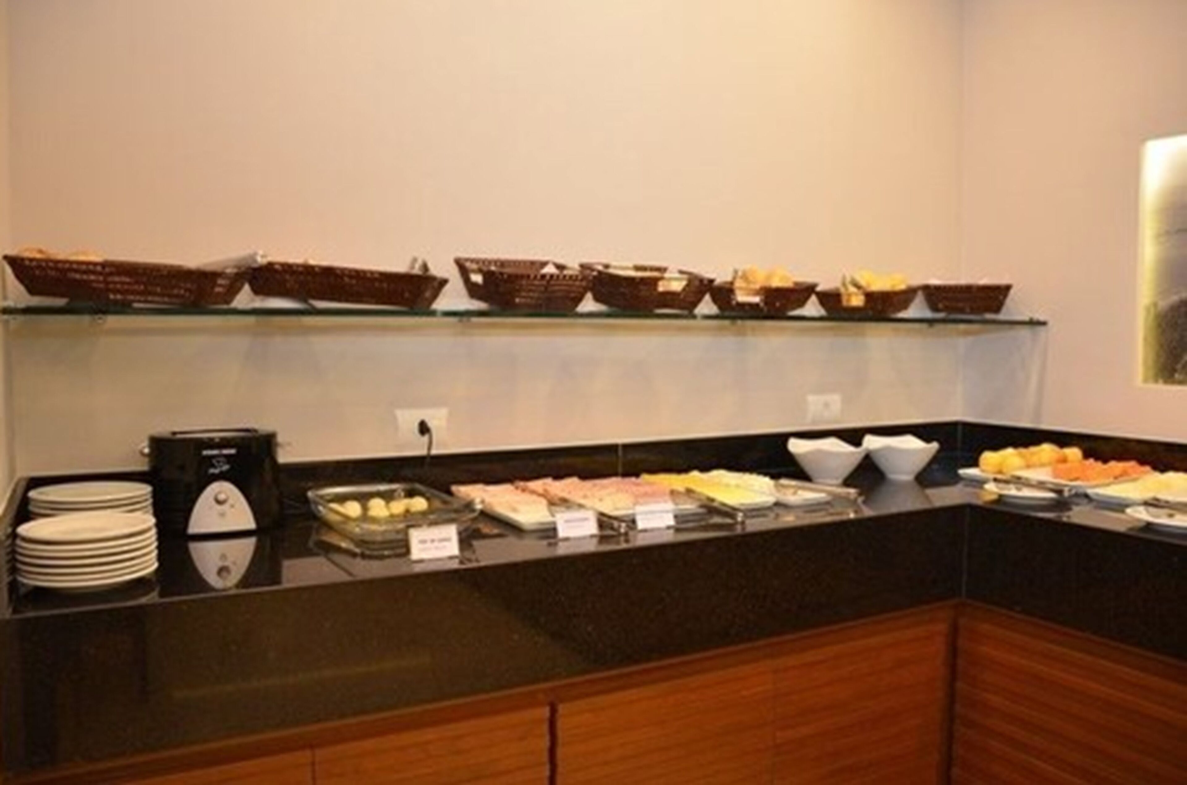 A buffet setup with various food items and a coffee machine.