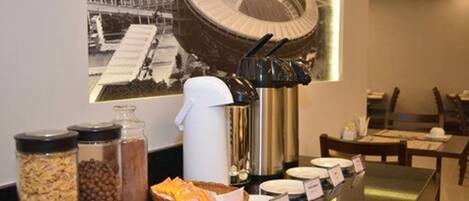 A breakfast buffet setup with various food items and a coffee machine.