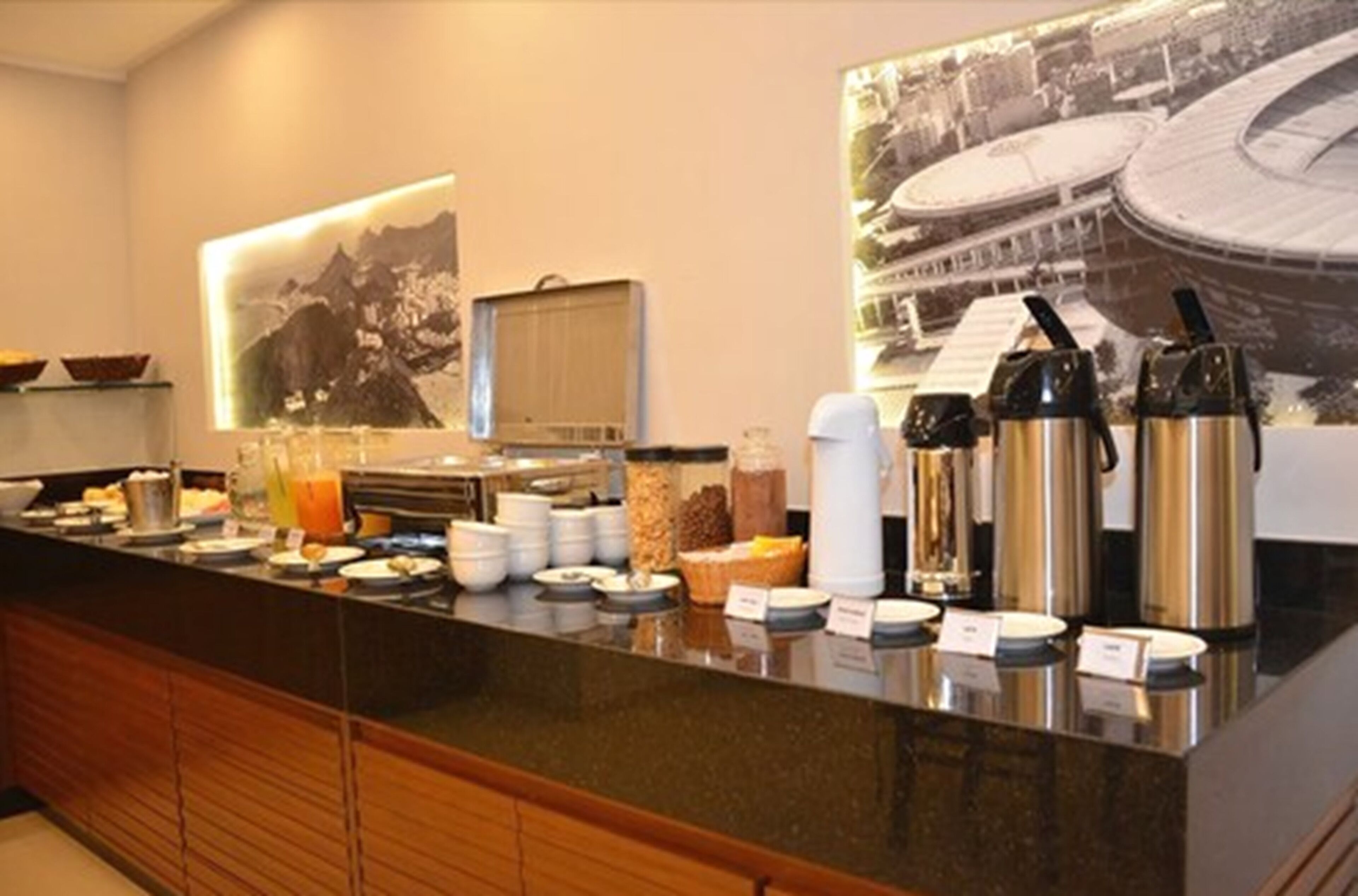 A breakfast buffet with various food items and hot beverages.