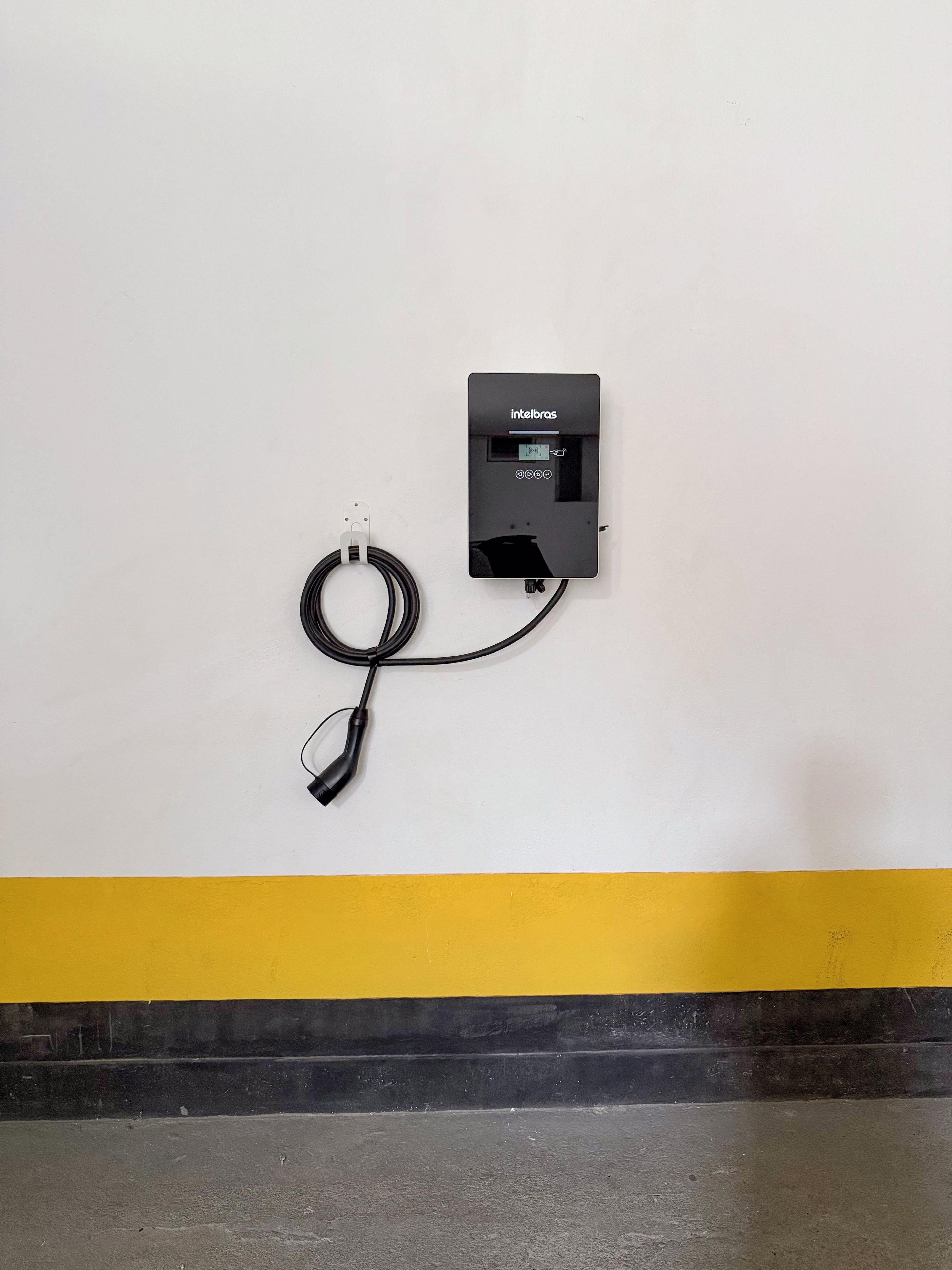 A wall-mounted power outlet with a cable connected to it.