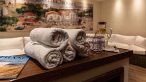 Une table bien rangée avec des serviettes pliées, un pichet en verre et un magazine, dans une chambre d’hôtel.