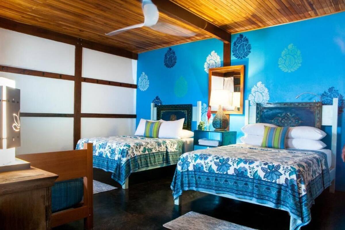 Habitación con dos camas, muebles de madera y decoración en la pared.