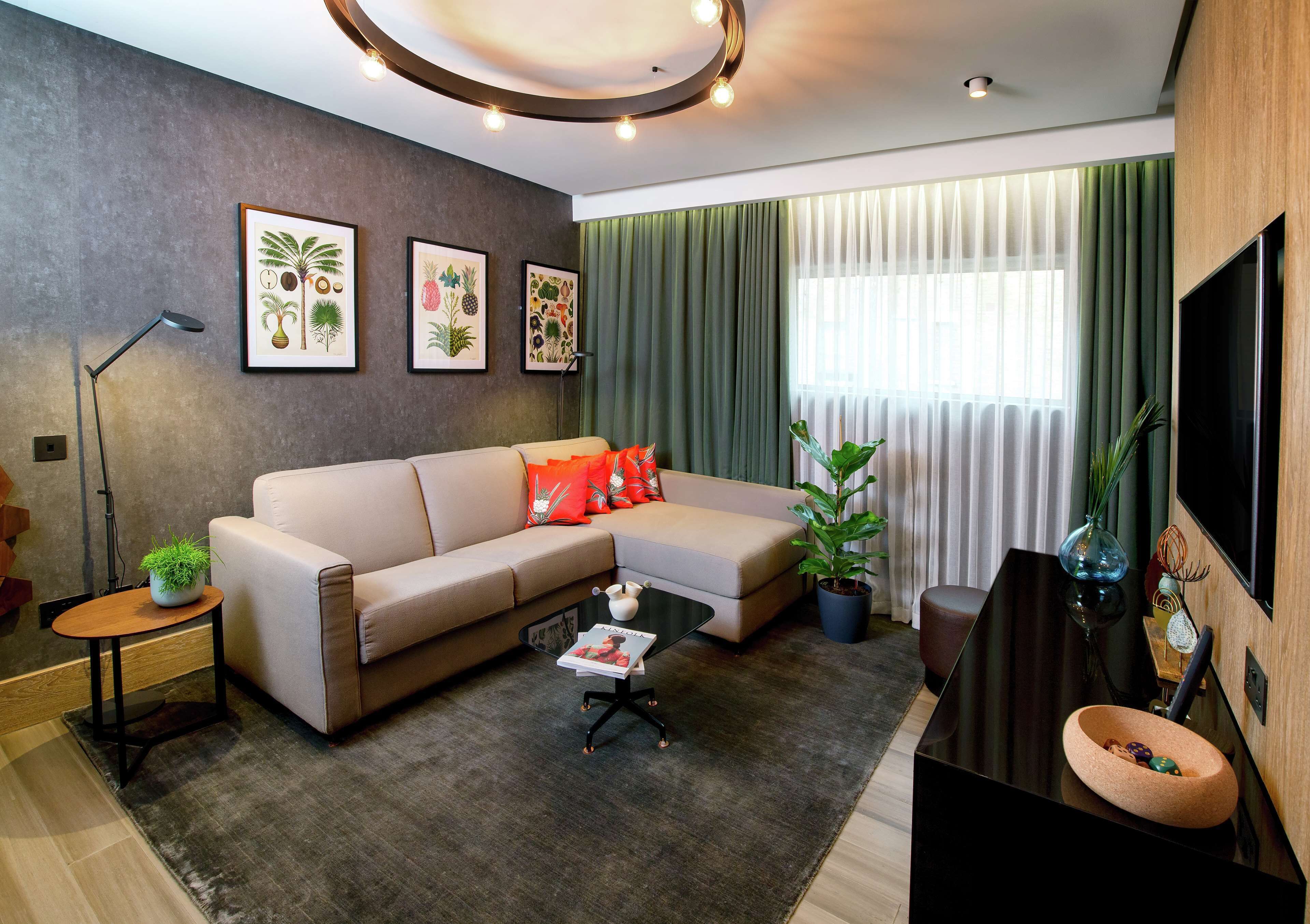 A modern living room with a sofa, coffee table, and a flat-screen TV.