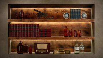 A wooden shelf with books, bottles, and a radio.