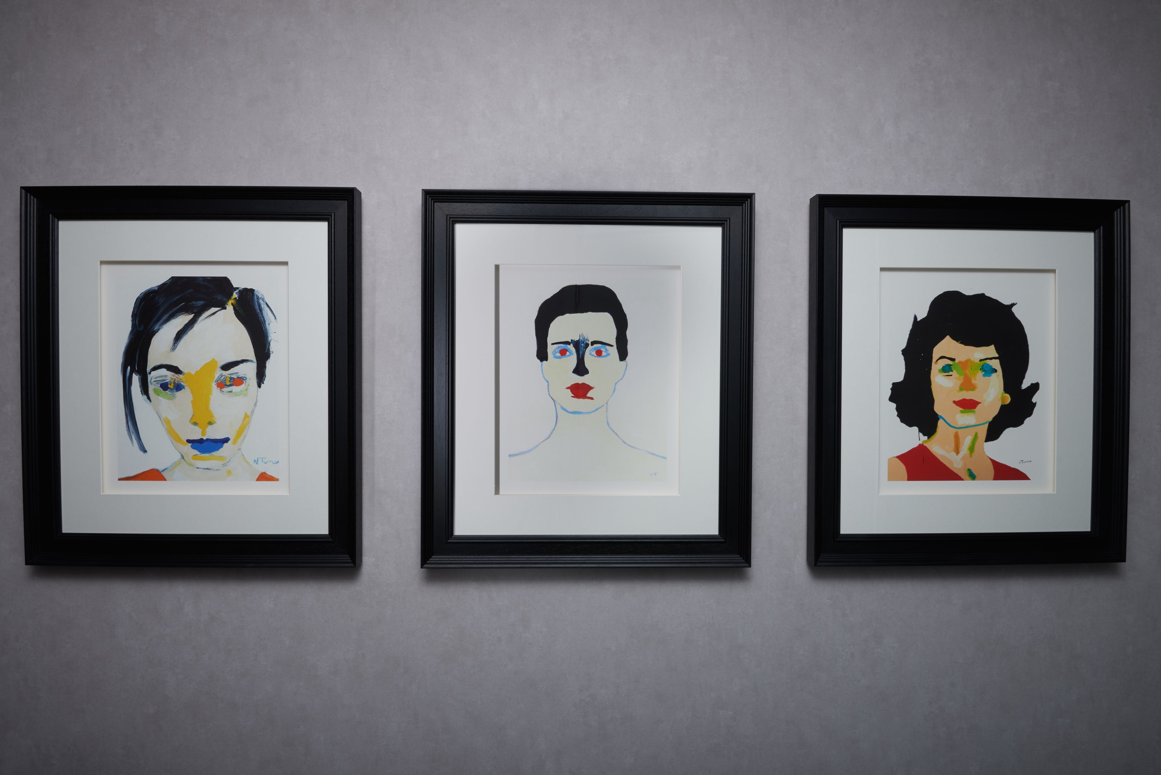 Three framed artworks on a wall.
