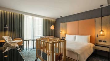Enjoy a comfortable stay in this stylish room with a large bed, wooden headboard, and a cozy chair.