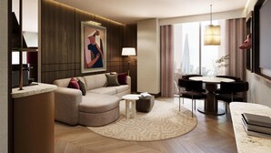 A modern living room with a sectional sofa, a round coffee table, a dining area with a table and chairs, and a large window with a city view. - Hilton London Bankside (London)