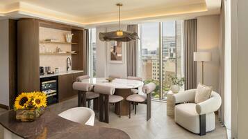 A modern living room with a dining area, a sofa, and a view of the city.