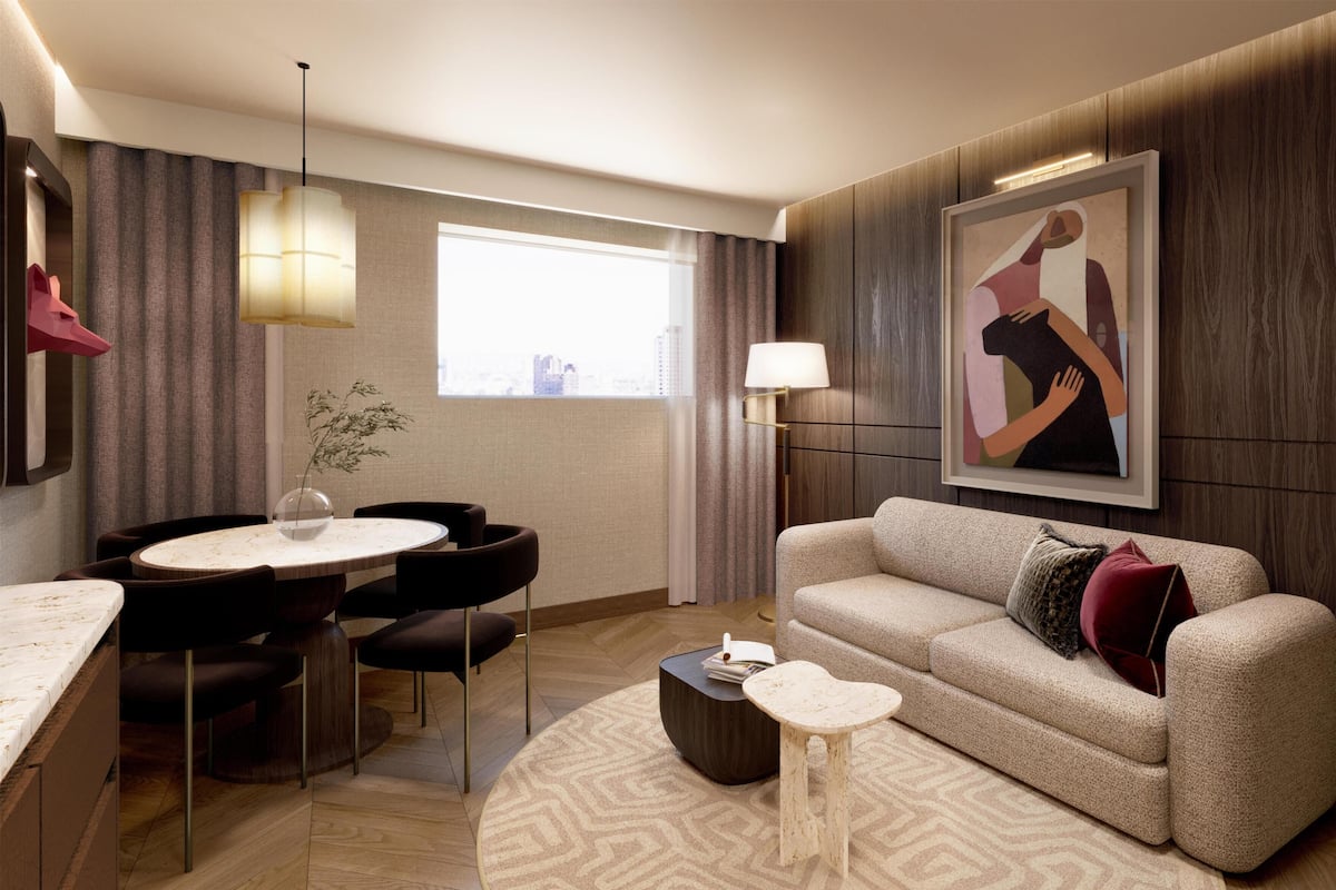 Una sala de estar moderna con una mesa de comedor redonda, un sofá, una mesa auxiliar y un cuadro en la pared.