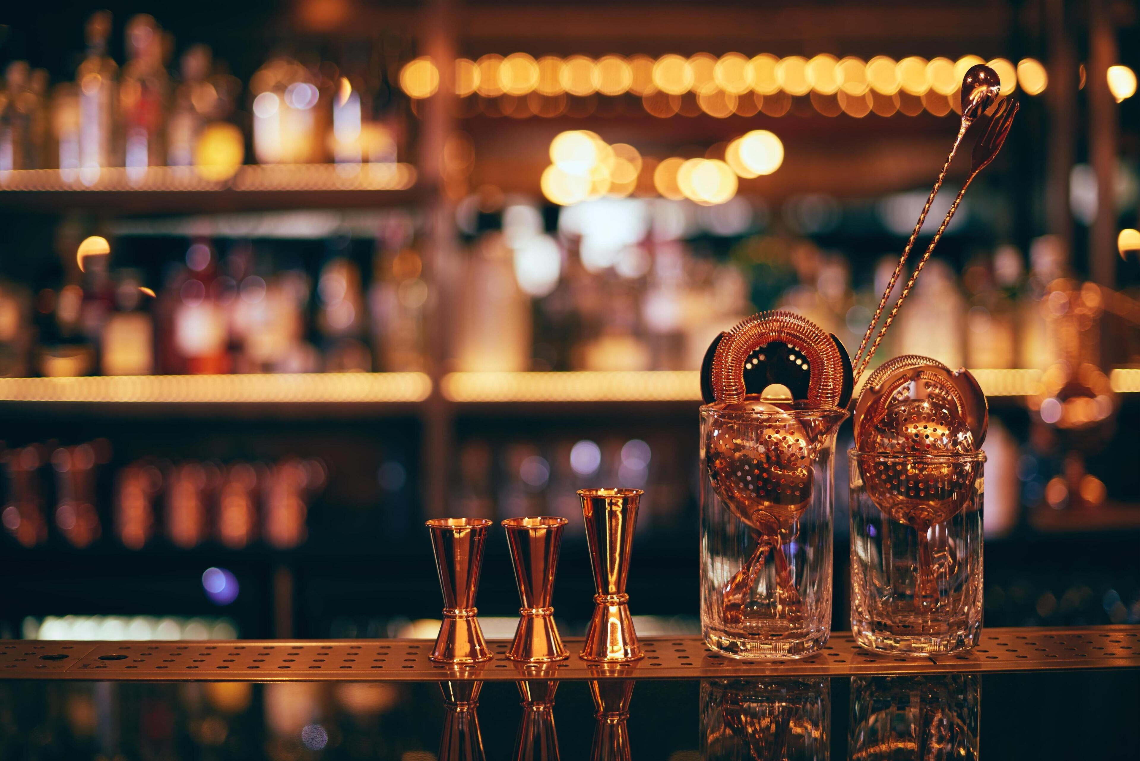 Een barsetting met een karaf, shotglaasjes en een lepel.