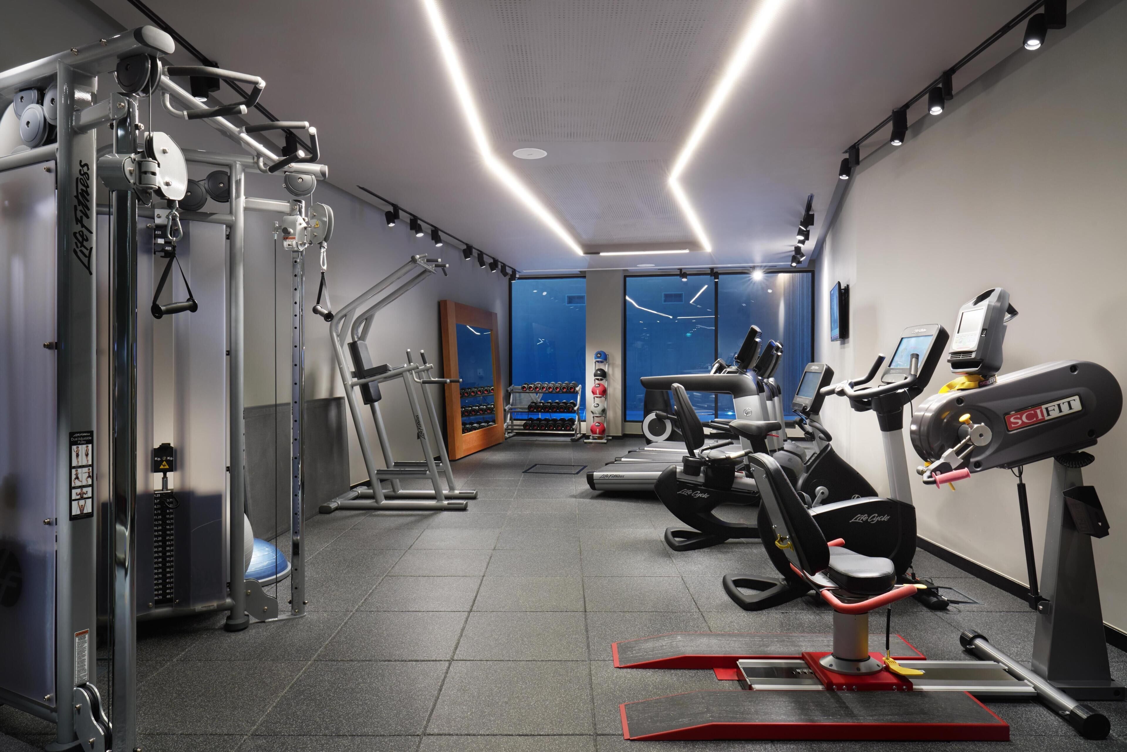 Ein Fitnessraum mit Laufbändern, Cardiogeräten und Krafttrainingsgeräten.