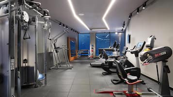 Ein Fitnessraum mit Laufbändern, Cardiogeräten und Krafttrainingsgeräten.