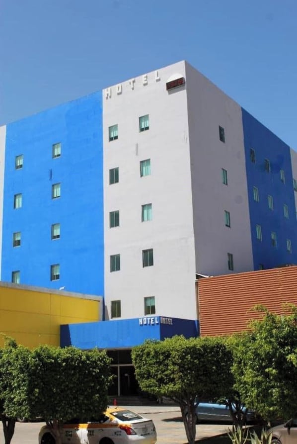 A multi-story hotel building with a blue and white facade, multiple windows, and a visible entrance. - Premier Inn Tuxtla (Tuxtla Gutierrez)