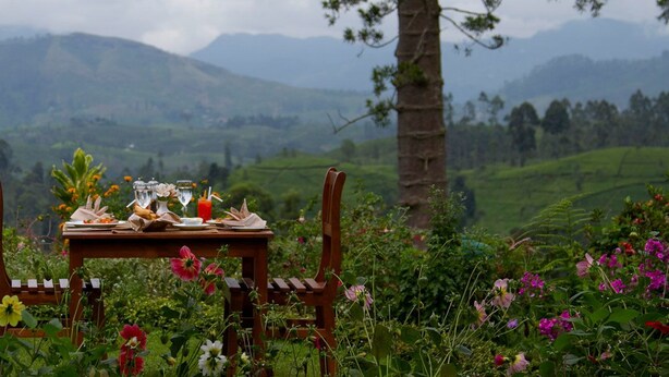Ein Tisch im Freien mit Blick auf Berge und üppige, grüne Landschaft.