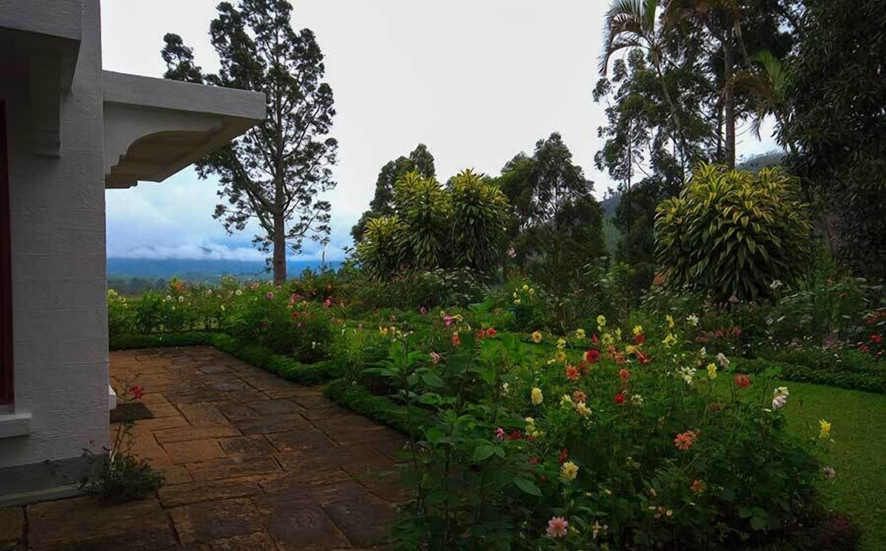 Un jardín con un sendero de piedra que conduce a un edificio blanco con una entrada cubierta.