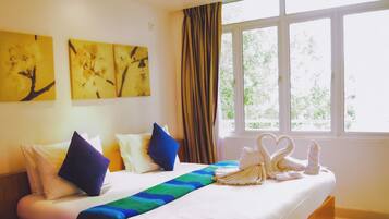 Habitación de hotel con cama, almohadas, manta y decoración en la pared.