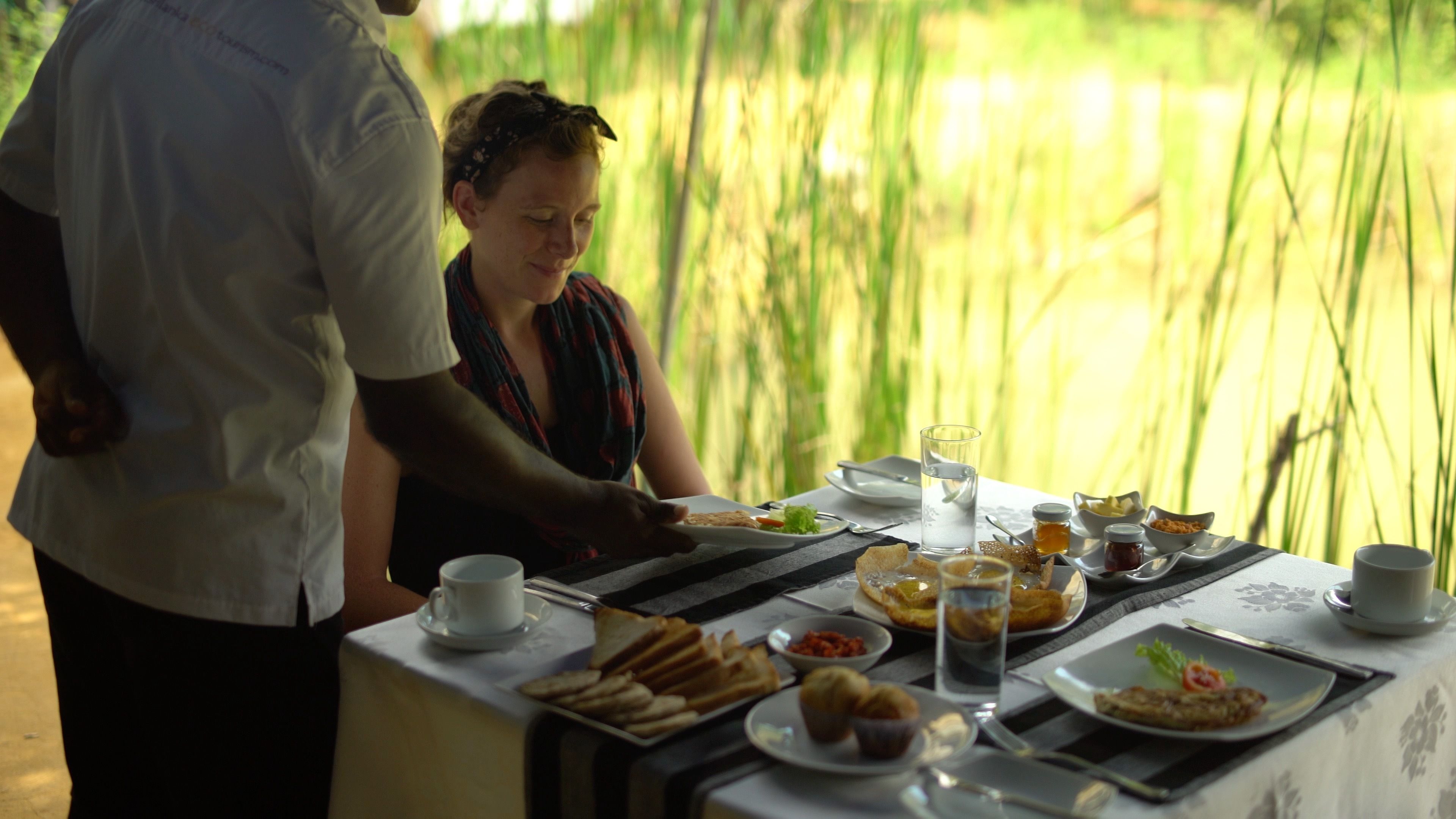 A dining table with plates of food, a glass of water, and a cup.