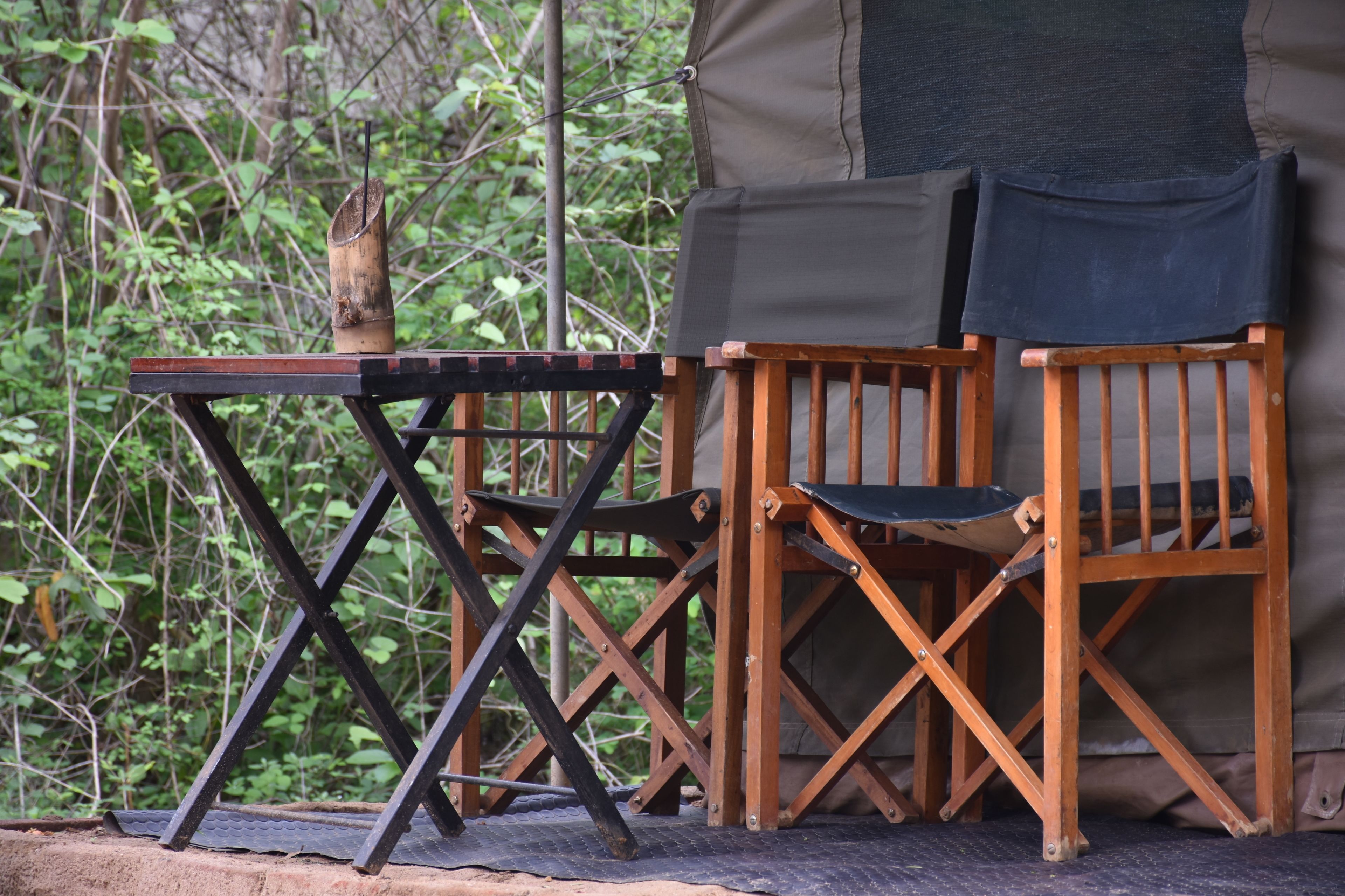 A wooden chair and table set up outdoors, likely for dining or relaxing.