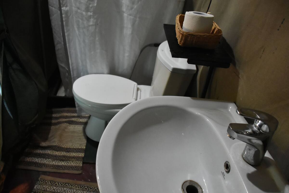 A bathroom with a white sink, a toilet, and a wicker basket on the wall.