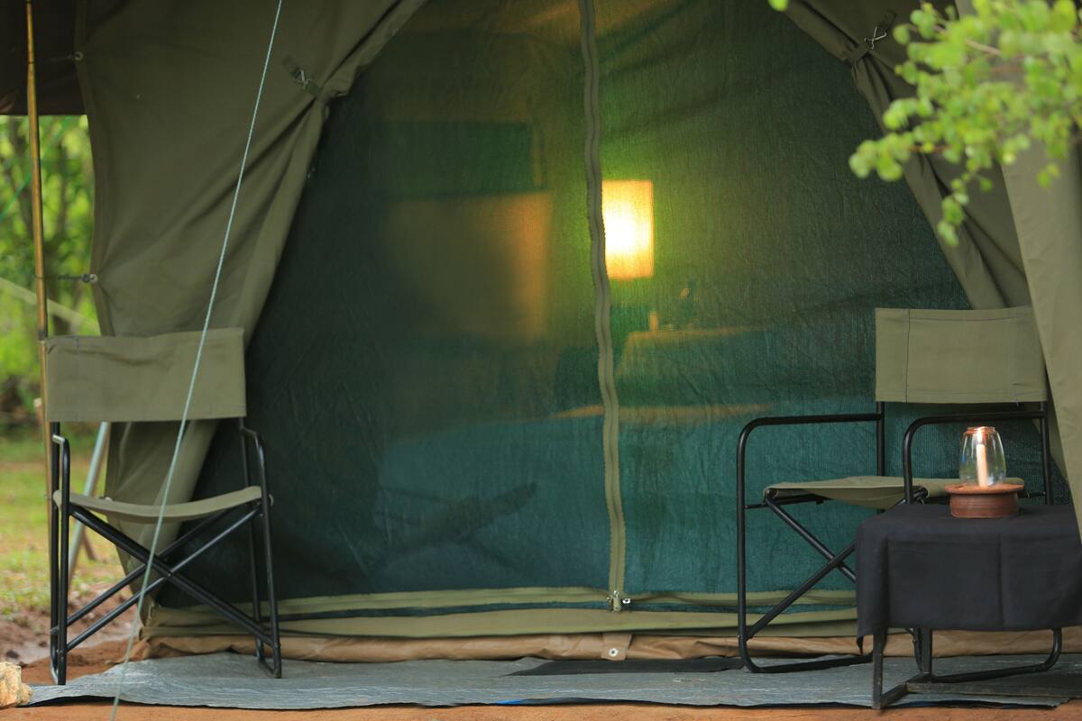 A tent with a table and chair set up inside.