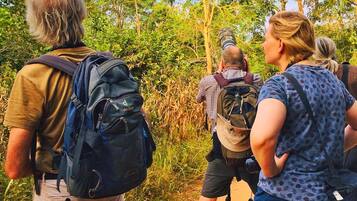 A group of people hiking on a dirt path surrounded by greenery.