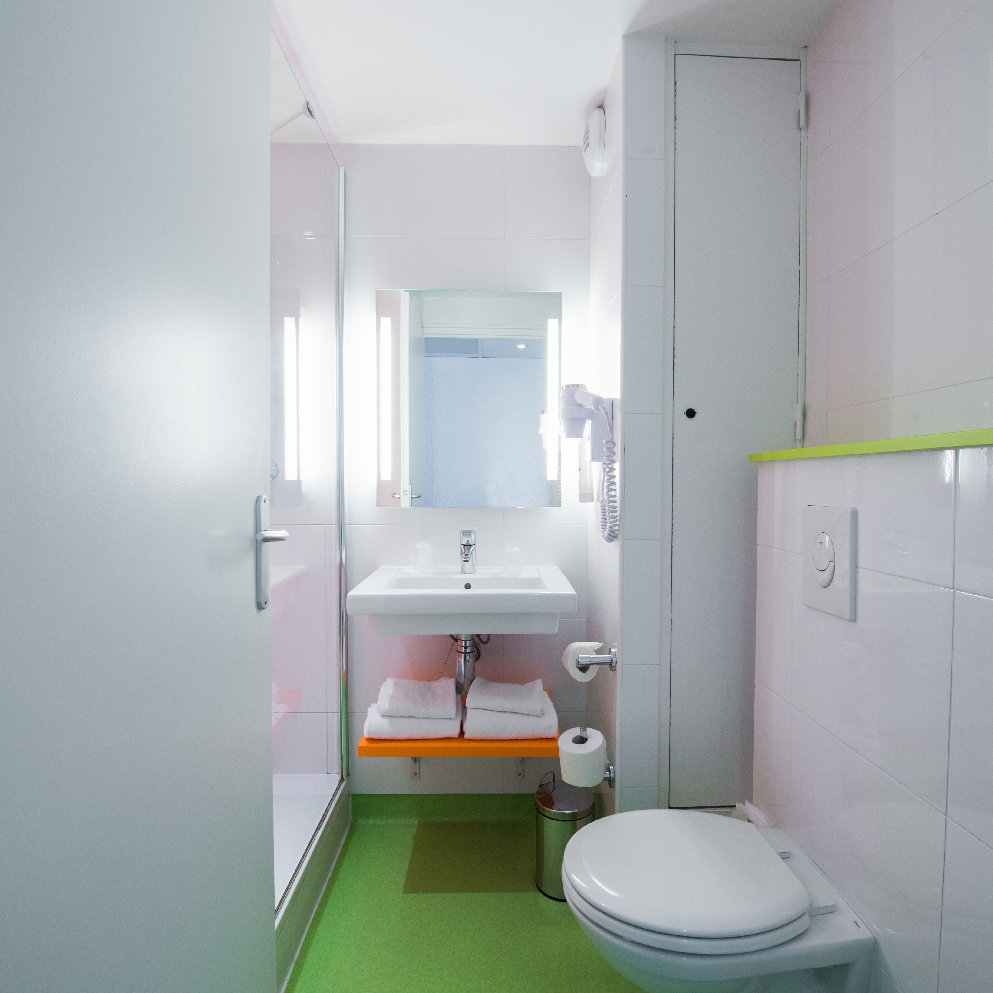 A compact bathroom with a white sink, mirror, and toilet.