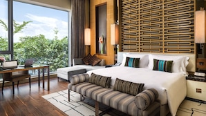 A modern hotel room with a large bed, a sofa, a desk with a laptop, and a view of greenery outside. - The Olympian Hong Kong (Kowloon)