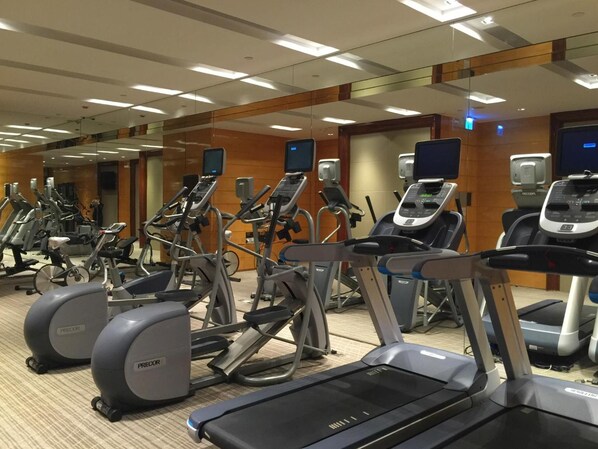 A gym with multiple treadmills, ellipticals, and stationary bikes. - The Olympian Hong Kong (Kowloon)