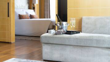 A modern living room with a grey sofa, a champagne bucket, glasses, and a small gift box.