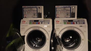 Deux machines à laver à chargement frontal, dotées de panneaux de commande et d’instructions de sécurité.