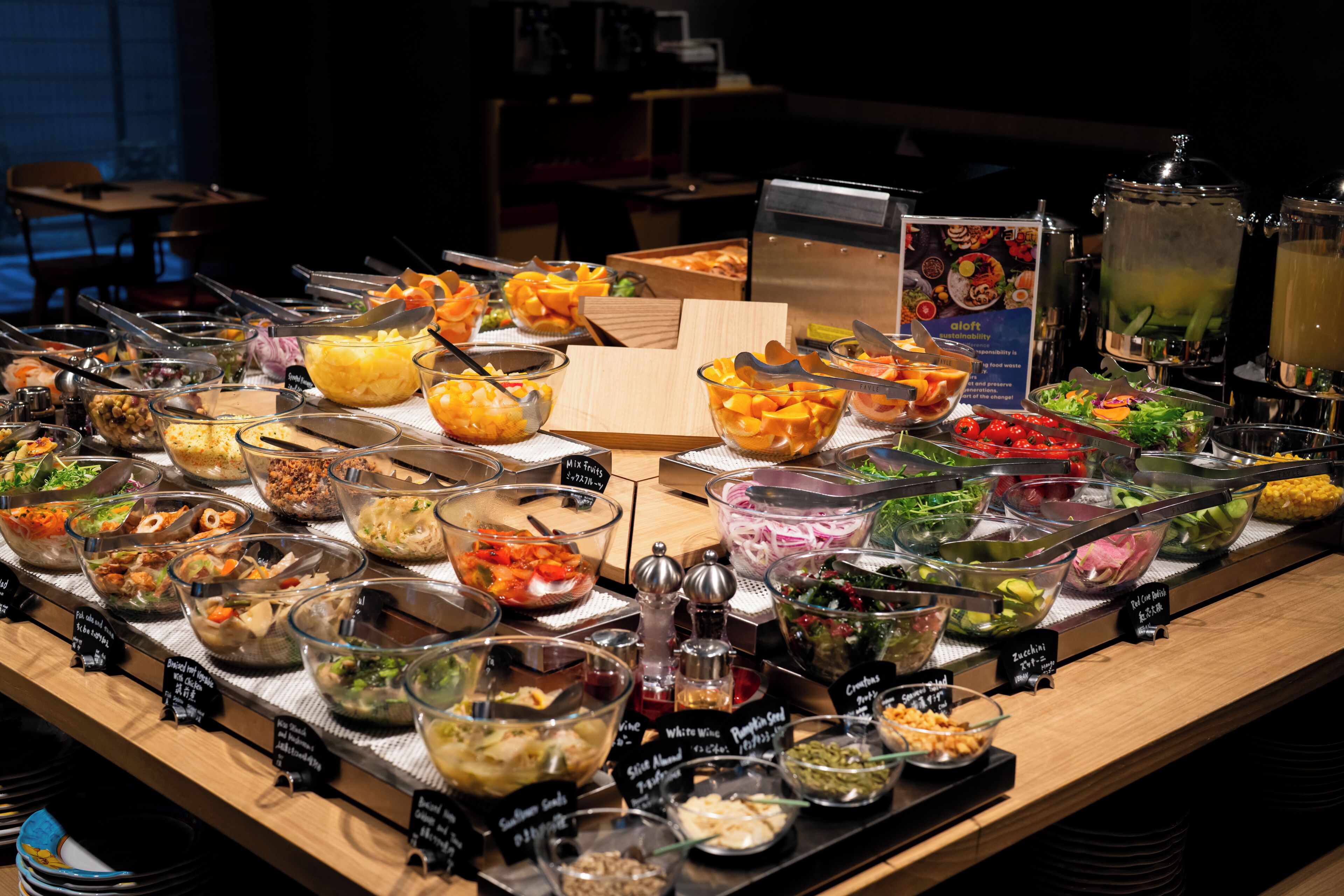 Un buffet proposant une variété de plats et un espace où l’on peut se servir soi-même pour les boissons.
