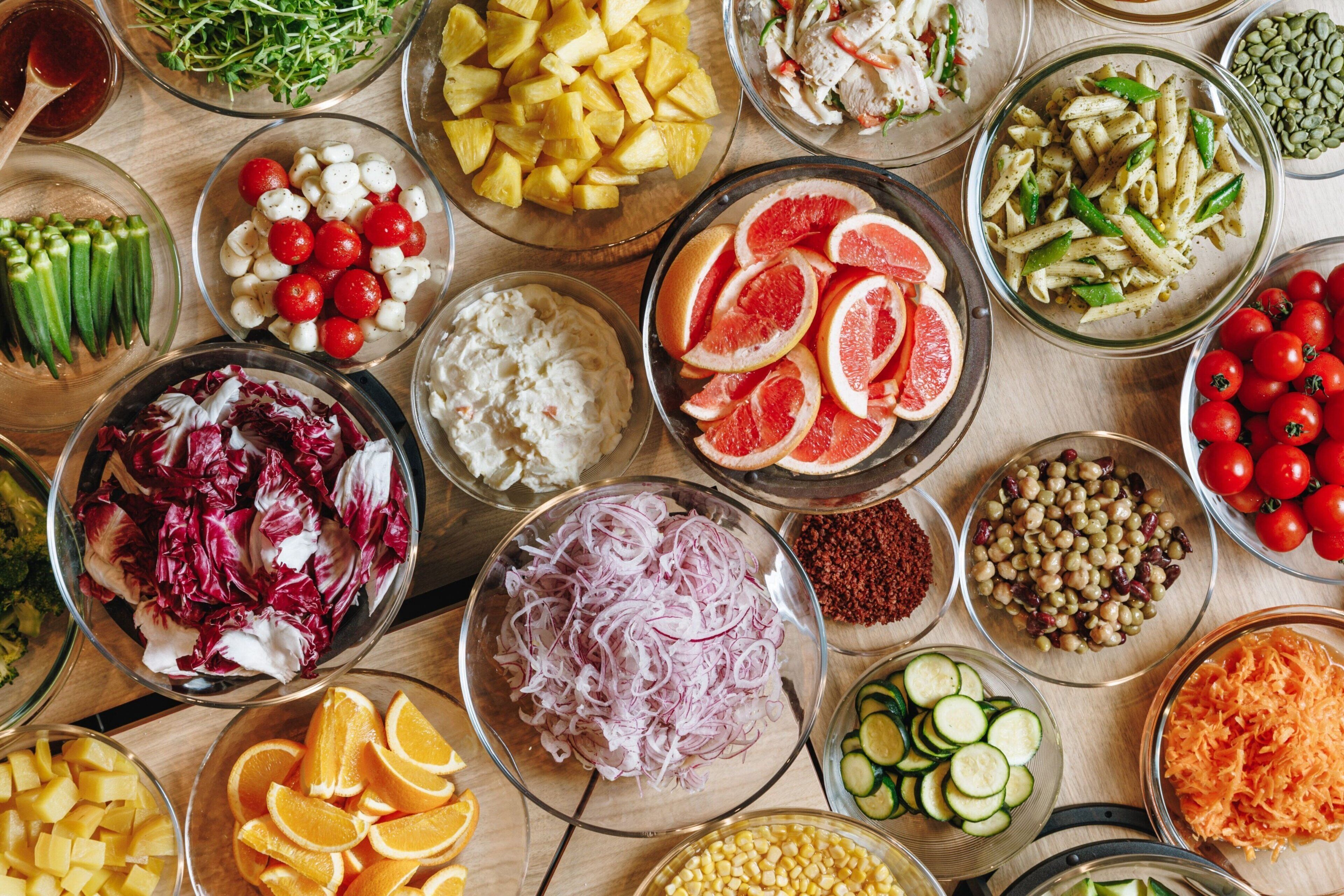 Variedad de frutas y verduras frescas dispuestas sobre una mesa de madera.