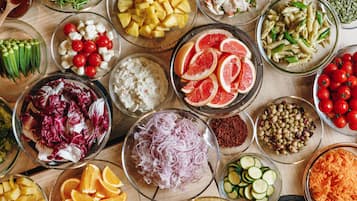 Variedad de frutas y verduras frescas dispuestas sobre una mesa de madera.