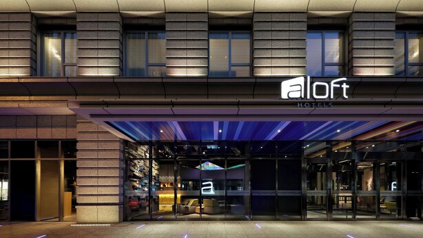 A modern hotel entrance with a glass facade, a reception desk, and a visible interior seating area. - Aloft by Marriott Osaka Umeda (Osaka)