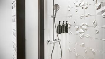 Eine moderne Dusche mit Regendusche, Handbrause und einer fest installierten Bedienkonsole.