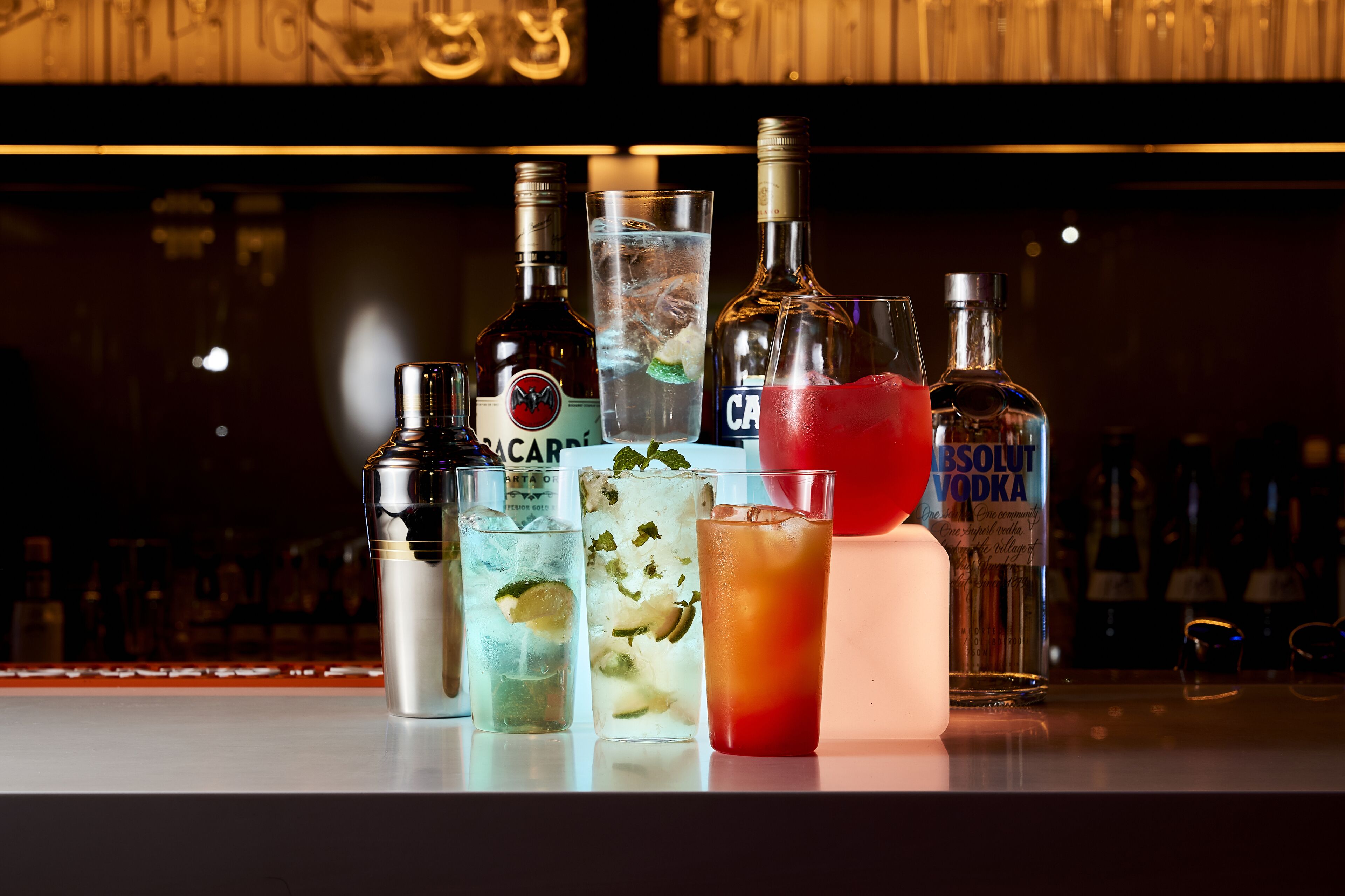 A bar with various bottles and glasses of drinks.