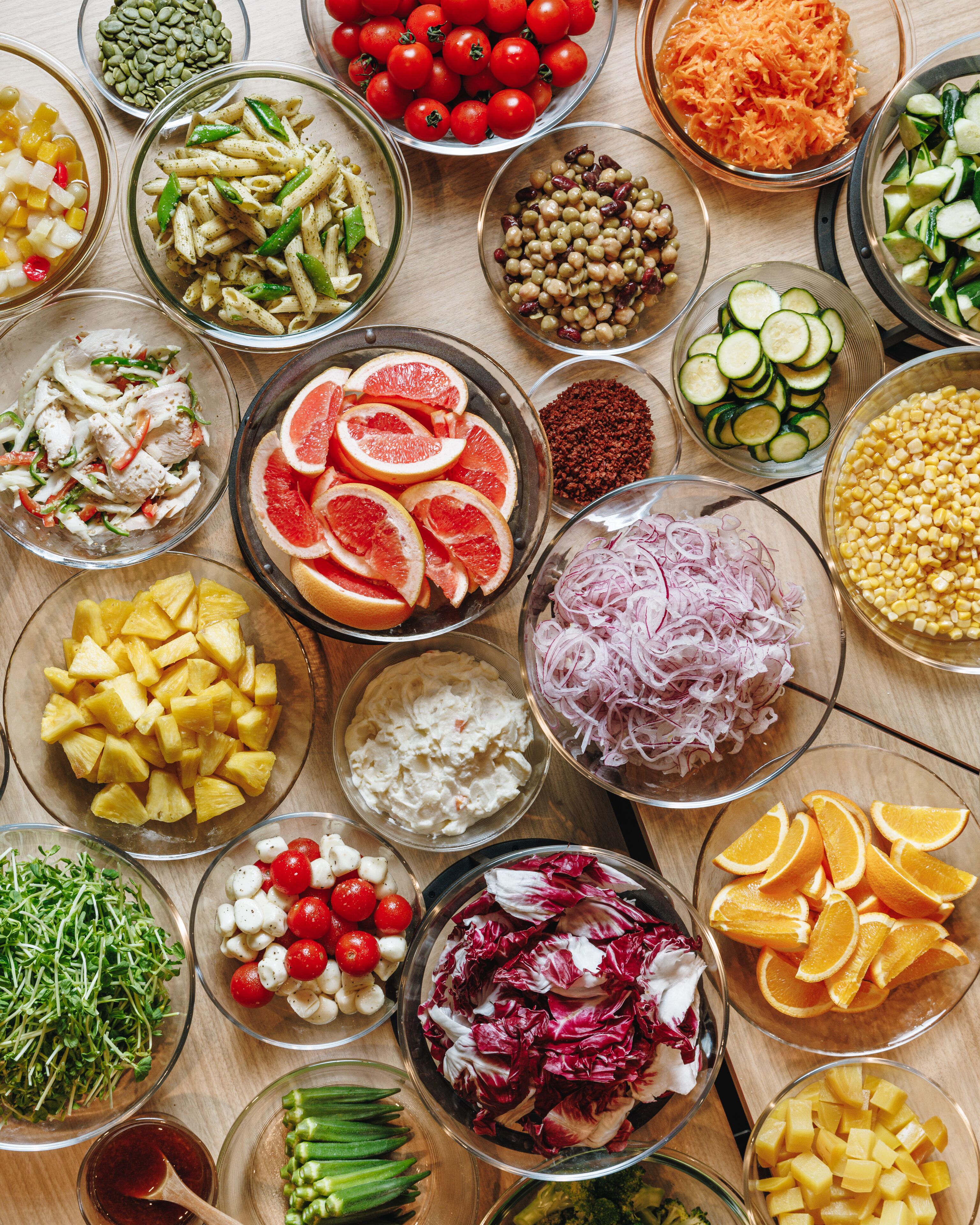 A variety of fresh fruits and vegetables arranged on a wooden table.