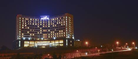 Ett hotell med flera våningar och en framträdande skylt högst upp.